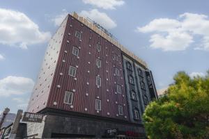 un alto edificio rosso con quadrati bianchi sopra di V Hotel a Gumi