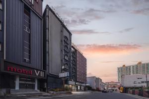 una strada cittadina con un cartello di un motel wii su un edificio di V Hotel a Gumi