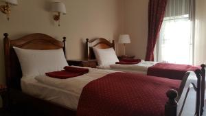 - une chambre avec 2 lits dotés de draps rouges et blancs dans l'établissement Szent György Villa Apartmanház, à Hévíz