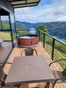 un tavolo e sedie su un balcone con vasca idromassaggio di Cabaña Refugio Amani a Norcasia