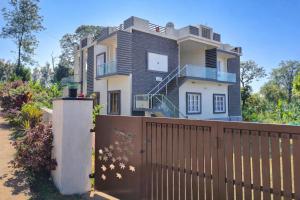 een huis met een hek ervoor bij Empra Exotica in Madikeri