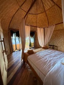 una camera da letto in una tenda con un letto e finestre di Cambaya Beach Resort a Busuanga Altre 51 foto