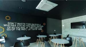 a room with tables and chairs and a tv on the wall at Seven bee boutique hotel in Surin