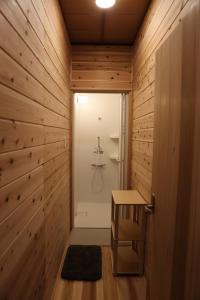 bagno con doccia e parete in legno di Riviera Iya Valley a Akano Altre 46 foto