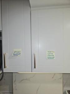 a kitchen with white cabinets with signs on them at 2 Bed, 1 Bath- Main floor, 2 Parking- Licensed in Oakville
