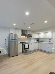 a kitchen with white cabinets and a stainless steel refrigerator at 2 Bed, 1 Bath- Main floor, 2 Parking- Licensed in Oakville