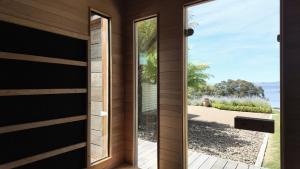 eine Tür zu einem Haus mit Blick auf das Meer in der Unterkunft Flowerpot Cottage Hideaway in Middleton