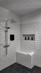 ein weiß gefliestes Bad mit einer Dusche und einer Badewanne in der Unterkunft Flowerpot Cottage Hideaway in Middleton