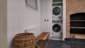 eine Waschküche mit einer Bank, einer Waschmaschine und einem Trockner in der Unterkunft Flowerpot Cottage Hideaway in Middleton