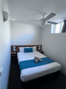 een slaapkamer met een bed met een knuffeldier erop bij Citigate Motel Newcastle in Newcastle +57 foto's