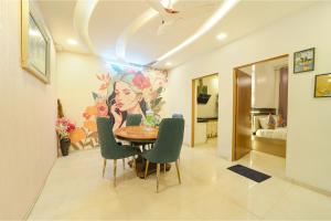 una sala da pranzo con tavolo, sedie e un dipinto di FabHotel Blooming Beds Pearl a Jaipur