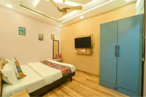 una camera da letto con un letto e una TV a schermo piatto di FabHotel Blooming Beds Pearl a Jaipur