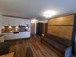 a kitchen with white cabinets and a couch in a room at Haus Roman Falch in Sankt Anton am Arlberg