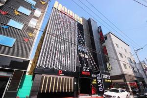 a tall building with lots of signs on it in a city at SU Motel in Gumi +6 photos