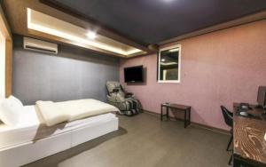 a room with a bed and a chair and a desk at SU Motel in Gumi