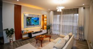 uma sala de estar com um sofá e uma TV em Luxury 2BR Apartment with AC, Wi Fi, Backup Power Ideal for Families , Bukoto em Kampala