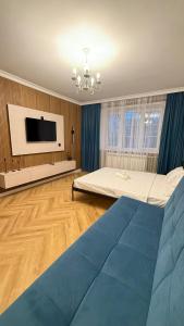 a bedroom with a large bed and a flat screen tv at Kurmangazy in Zhezdi