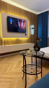 a room with a table and a tv on a wall at Kurmangazy in Zhezdi