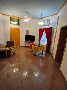 een woonkamer met een tafel en gele stoelen bij Qurum Heights Hotel in Muscat +25 foto's