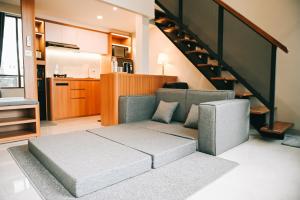 a living room with a couch and a staircase at Djayati Loft Stay in Yogyakarta