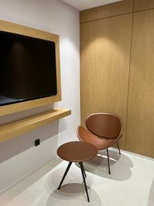 een kamer met een stoel en een tv aan de muur bij Busan Seomyeon Nestly Hotel in Busan