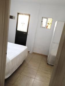 1 dormitorio con cama, ventana y puerta en Apartamentos MásBambú, en Málaga