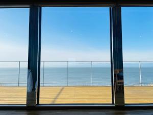 a room with a view of the ocean through a window at Yunagi 夕凪プライベートサウナ付ヴィラオーシャンフロントの絶景宿 夕日とサウナを満喫海と夕日に包まれる贅沢空間 in Mōrai +108 photos