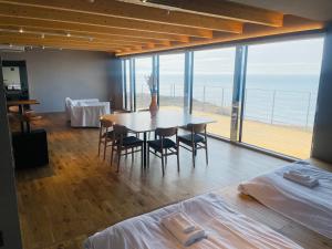 una sala da pranzo con tavolo e vista sull'oceano di Yunagi 夕凪 