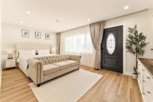 a bedroom with a bed and a couch and a window at Lyn's Stay in Westminster