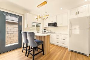 a kitchen with a white refrigerator and two bar stools at Lyn's Stay in Westminster +14 photos