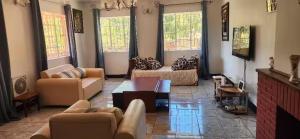 a living room with couches and a flat screen tv at SDG Lodge in Blantyre
