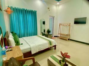 a bedroom with a bed and a blue curtain at Bee Homestay Phan Thiết in Phan Thiet