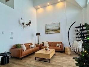 een woonkamer met een bank en een salontafel bij 404 - Nature & Luxury Penthouse - View & Pool in Baie-Saint-Paul