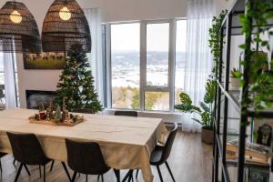 een tafel met een kerstboom in een kamer met ramen bij 404 - Nature & Luxury Penthouse - View & Pool in Baie-Saint-Paul +37 foto's