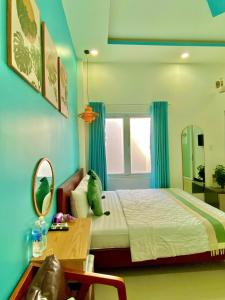 a bedroom with a bed and a table and a mirror at Bee Homestay Phan Thiết in Phan Thiet