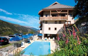 a hotel with a swimming pool in front of a building at Résidence Odalys L'Ecrin des Neiges in Valmeinier