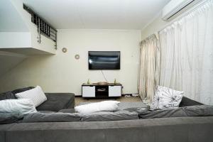 Una sala de estar con un sofá y un televisor de pantalla plana. en Royal Palm, en Mokopane 9 fotos más