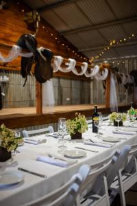 a long table with white plates and wine glasses at Drovers Run B&B and Events Venue 