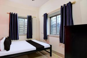 um quarto com uma cama com cortinas azuis e uma cama sidx sidx em Hotel O by OYO DA Guest Home em Jādabpur