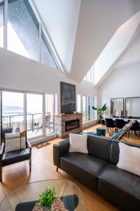 een woonkamer met een bank en een open haard bij 406 - Luxury Condo Le Clair-Obscur - View & Pool in Baie-Saint-Paul