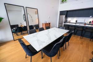 een eetkamer met een witte tafel en stoelen bij 406 - Luxury Condo Le Clair-Obscur - View & Pool in Baie-Saint-Paul +59 foto's