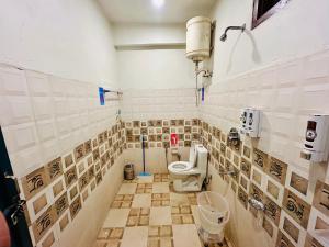 een betegelde badkamer met een toilet en een wastafel bij Kasol Hostel in Kasol +90 foto's