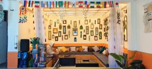 a living room with a couch and a wall with pictures at Kasol Hostel in Kasol