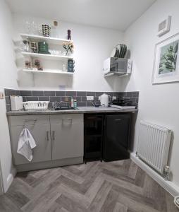 een keuken met een wastafel en een vaatwasser bij Loxley View Guest House in Hillsborough