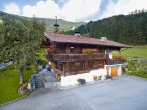 a large wooden house with flowers on the balcony at Alpen-Chalet-Pankraz in Fügenberg