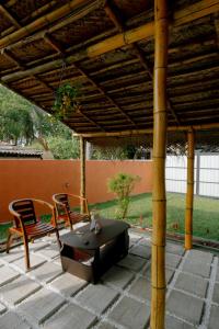 a patio with two chairs and a grill under a pergola at Social Stays in Negombo
