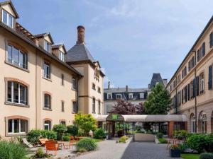 a courtyard in a building with tables and chairs at Ibis Styles Colmar Centre in Colmar