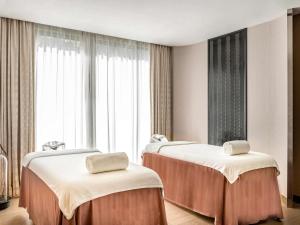 twee bedden in een hotelkamer met een raam bij V Villas Hua Hin - MGallery Collection in Hua Hin