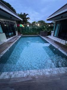 a blue tile swimming pool in a house at Stingless Villa in Ban Ket Ho