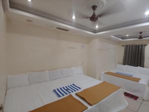 En eller flere senge i et værelse på Ambai Guest House